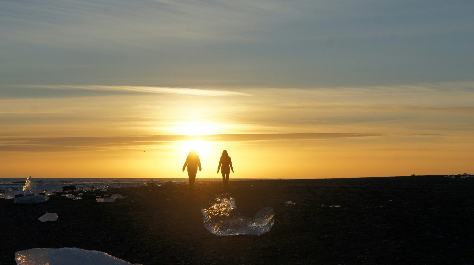 silhouette of couple standing on beach during sunset